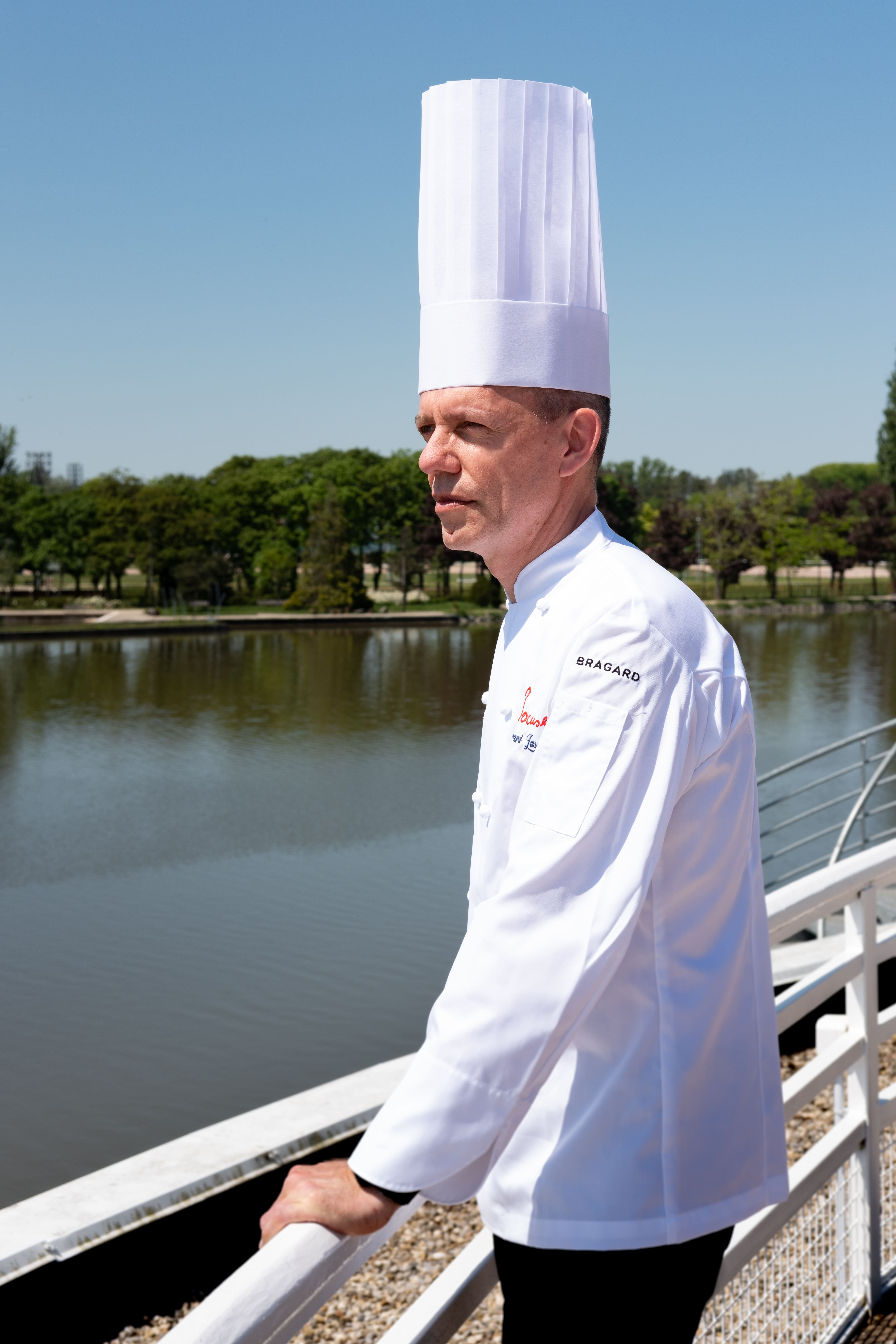 Le Chef Lasne en veste blanche, observant l’Allier depuis la terrasse du restaurant La Rotonde à Vichy.