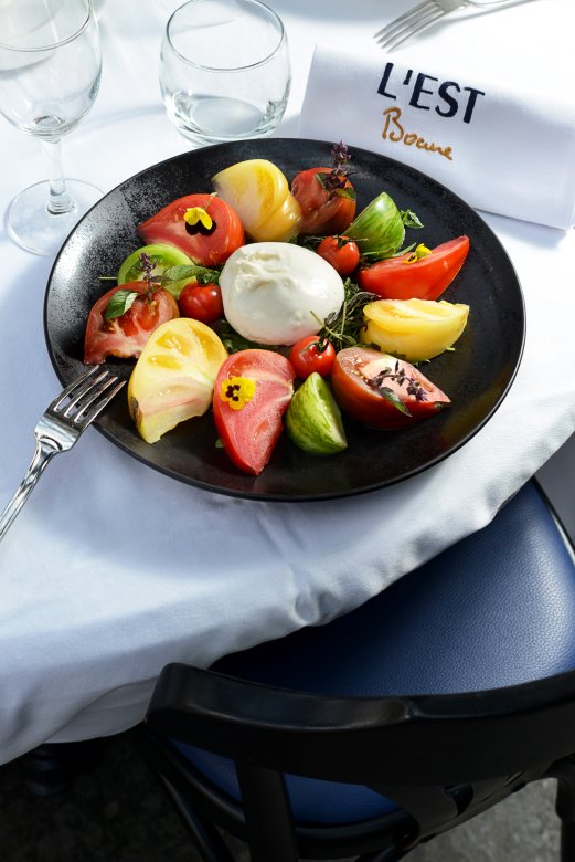 Assiette de burrata avec tomates multicolores, servie à la Brasserie L’Est à Lyon.