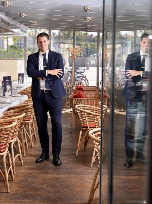 Charles Astier, responsable de la Brasserie Le Sud, debout dans la véranda du restaurant à Lyon.