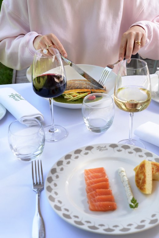 Repas en terrasse au Restaurant Fond Rose à Lyon avec assiette de saumon fumé, filet de poisson et verres de vin.