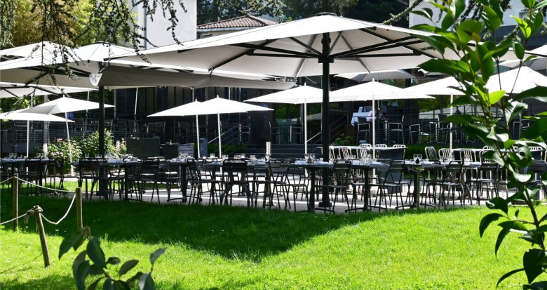 Terrasse ombragée de la maison Fond Rose à Lyon, au cœur d’un jardin arboré.