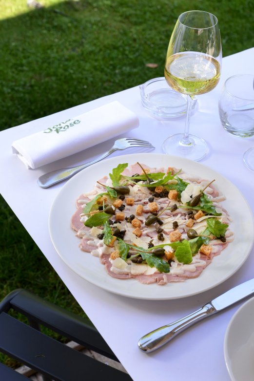 Assiette de vitello tonnato servie en terrasse avec un verre de vin blanc au restaurant Fond Rose à Lyon