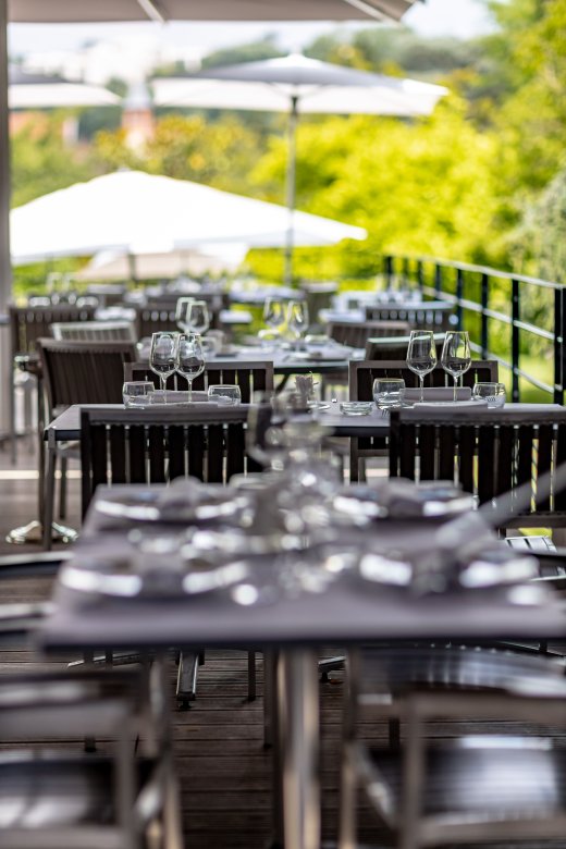 Terrasse élégante de la Maison Fond Rose à Lyon, dressée pour le service, avec vue sur le jardin.