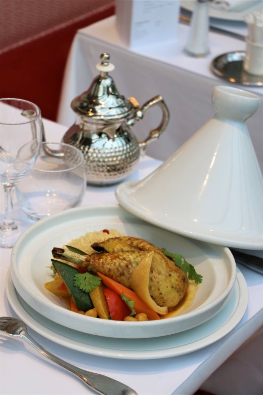 Tajine de volaille aux légumes servi dans une tajine blanche à la Brasserie Le Sud à Lyon.