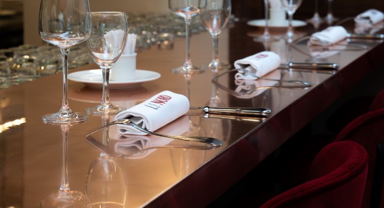 Table élégamment dressée à la Brasserie Le Nord avec verres et serviettes marquées.