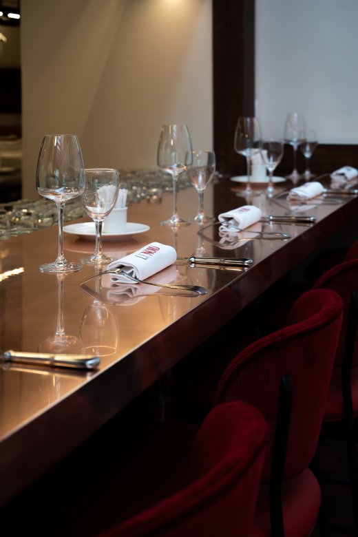 Table élégamment dressée à la Brasserie Le Nord avec verres et serviettes marquées.
