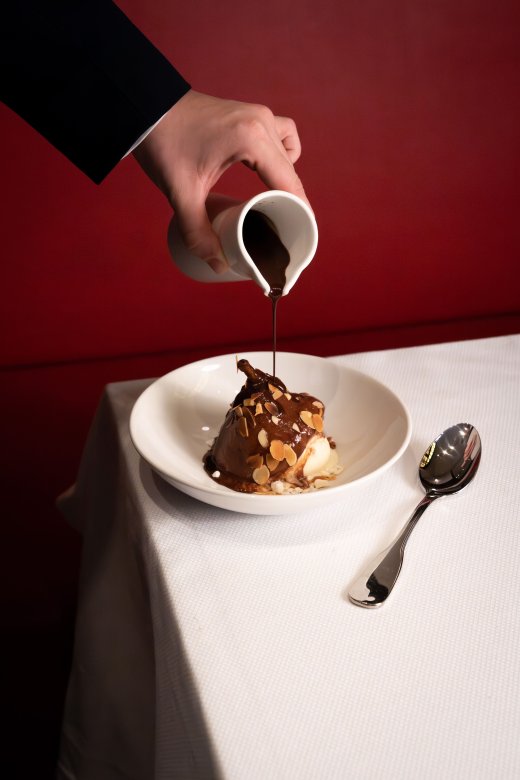 Service d’un dessert glacé nappé de sauce chocolat à la Brasserie Le Nord.