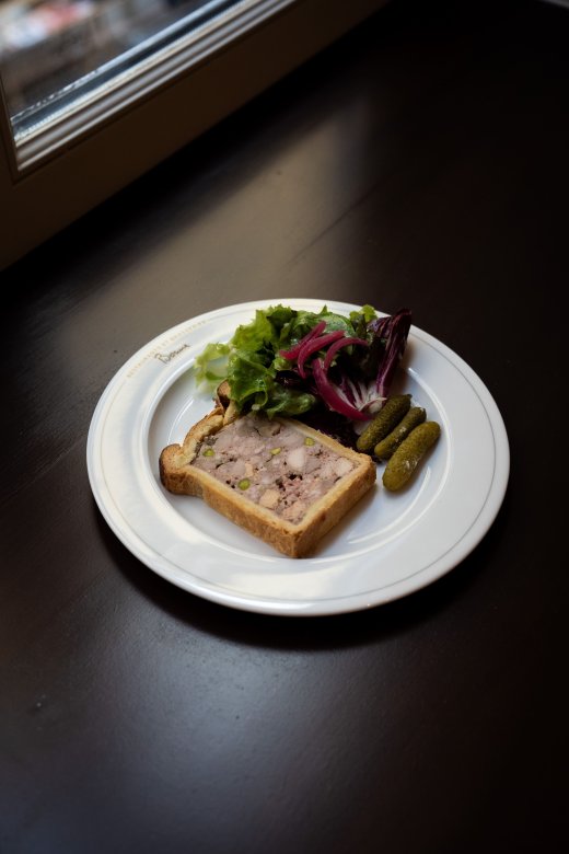 Pâté en croûte maison avec salade et cornichons servi à la Brasserie Le Nord.
